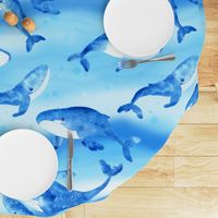 Whales swimming in tranquil waters in the deep blue ocean on ocean blue and aqua blue background