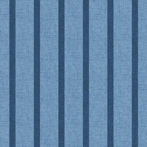 1" wide indigo denim pencil stripes on a chambray blue, faux denim woven textured background. 