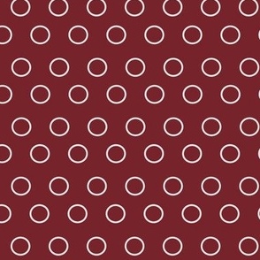 Graphic circles or open dots, light gray on burgundy.
