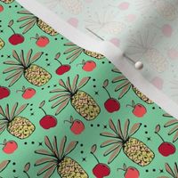 Pineapple, apple, cherry on green background