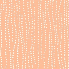 Hand drawn white  dots on orange background (Pantone’s peach fuzz)