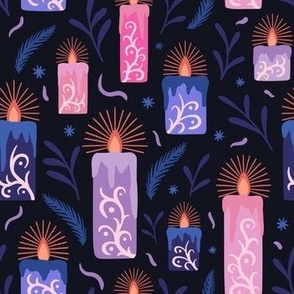 Lit ornate candles at night - blue, pink and purple on black background