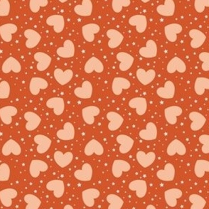 Small tossed Hearts with stars peach fuzz on rusty red | f6be9d