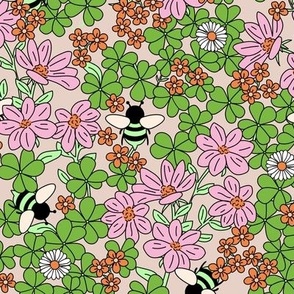 Cutesy English flower garden and bees green leaves and blossom green pink on sand 