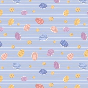 Colourful tossed easter eggs on stripe in blue