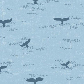 whale fins in light cerulean blue textured wavy ocean