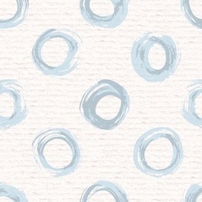 Hand drawn watercolour circles and rings – painted geometric brush strokes on a warm cream watercolour paper texture. Beige and ecru with thermal blue and baby blue.