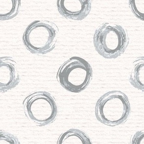 Hand drawn watercolour circles and rings – painted geometric brush strokes on a warm cream watercolour paper texture. Beige and ecru with upward grey and slate blue-gray.