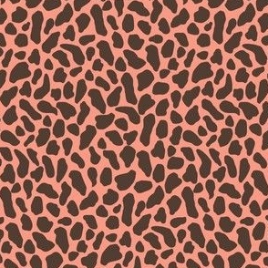 Small wild animal print, two color, peach dark sepia brown on a peach pink ground.