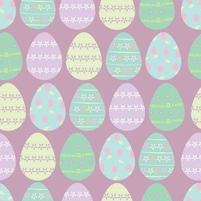 purple background with pastel chocolate easter eggs pattern
