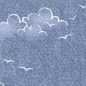 Chambray Cotton Clouds with Seagulls in Stonewash Blue (large scale) | Summer sky, hand drawn clouds and birds on natural cotton, chambray pattern, warp and weft weave pattern, seaside sky on stonewash denim blue, ocean decor.
