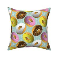 Assorted Glazed Donuts on Light Teal With Sprinkles