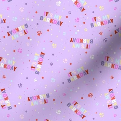 Colorful rainbow barkday design with confetti paws and happy birthday text tossed for dogs on bright lilac purple 