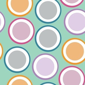 Purple, orange, blue, and pink plates composition on an aqua background for retro backdrop effect