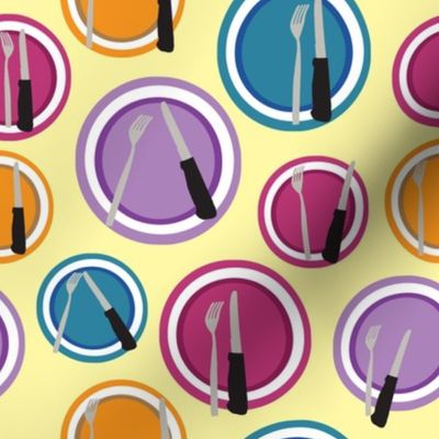 Purple, orange, blue, and pink plates composition with cutlery on an light yellow background