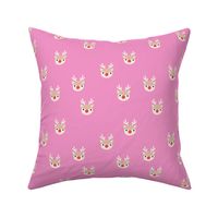Little kawaii Christmas Rudolph reindeer with antlers and red nose on pink spaced 