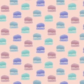 Hand painted macaroons in pink, blue, teal, and purple on a light peach background - large