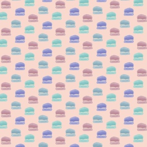 Hand painted macaroons in pink, blue, teal, and purple on a light peach background - medium