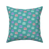 Hand painted macaroons in pink, blue, teal, and purple on a teal background - medium