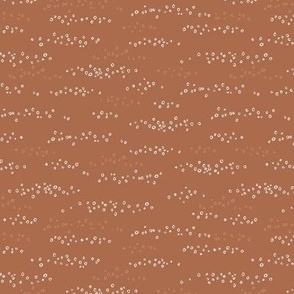 Hand drawn scattered white circles on sienna brown