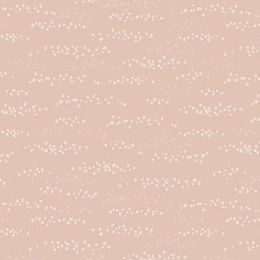 Hand drawn scattered white circles on muted pink