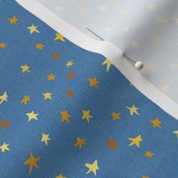 4” repeat tiny gold, bronze and yellow effect scattered, tossed non directional stars, blender for afternoon tea On cornflower blue