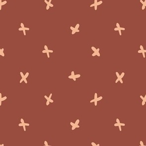 Hand-drawn playful cross in polka dot style - salmon pink on marsala red background
