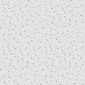 Polka dot pattern. Small white, gray, black polka dots on a light gray background.