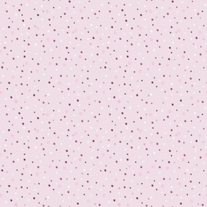 Polka dot pattern. Small white, pink, brown polka dots on a pink background.