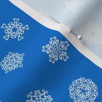 cut-paper snow stars on Christmascolors blue