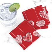 White lace hearts on a red background, a romantic and festive pattern.