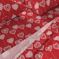 White lace hearts on a red background, a romantic and festive pattern.