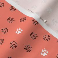 Trotting paw prints - black on coral with white