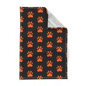 Pawprint Polka dots - 1 inch (2.54cm) - Mid Orange (#FF5F00) on Black (#000000)