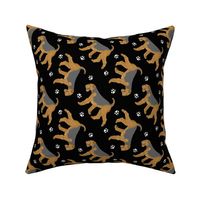 Trotting Airedale Terrier and paw prints - black