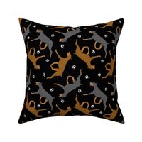 Trotting Doberman Pinschers and paw prints - black