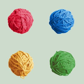 little yarn balls - Christmascolors red, blue, green, yellow on pale glitter green