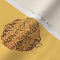 knitting in the morning:  self-striping yarn balls in copper and brown on gold