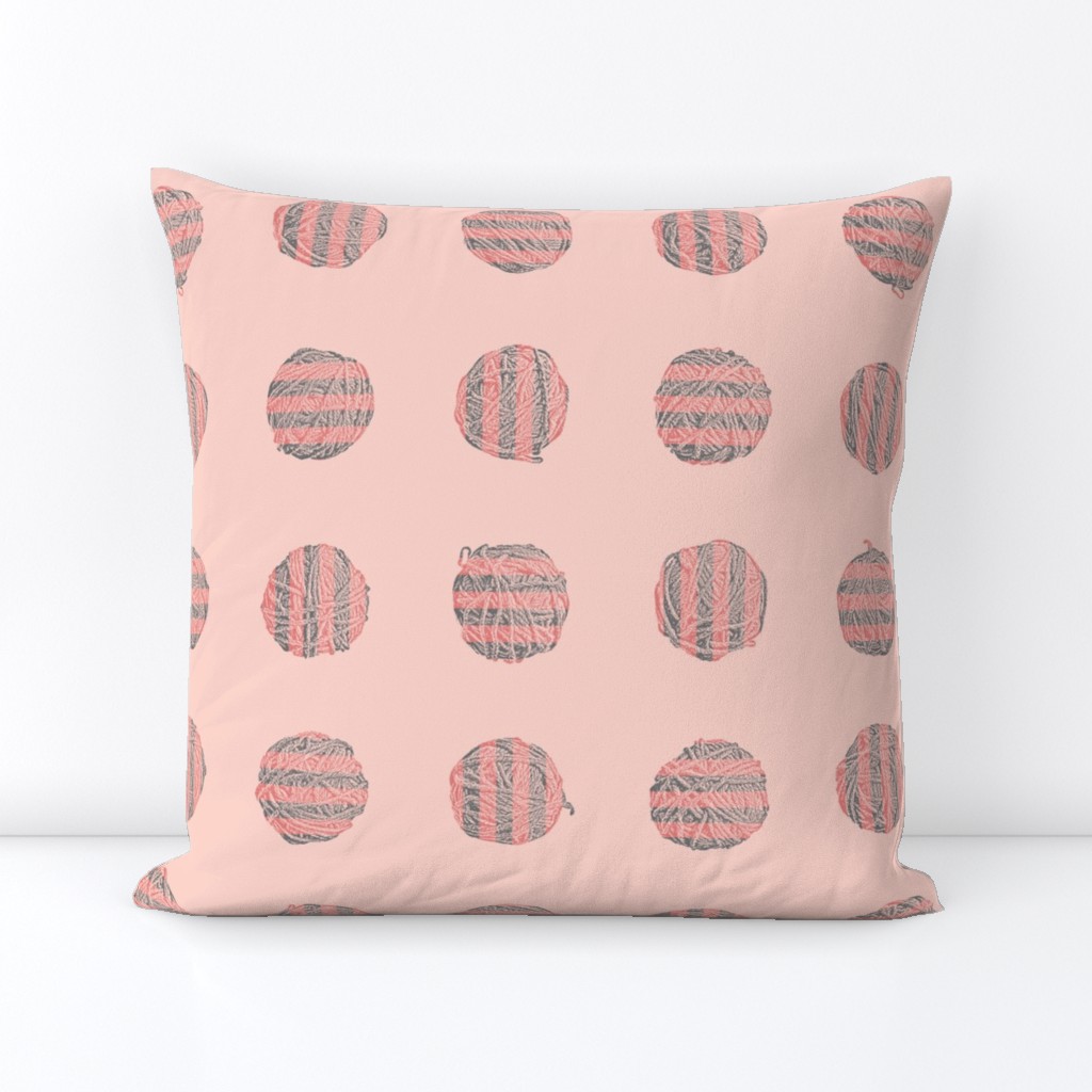 self-striping yarn balls in coral and grey on pink