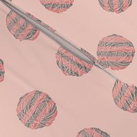 self-striping yarn balls in coral and grey on pink