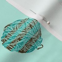 self-striping yarn balls in brown and teal on pale aqua
