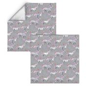 Mom and baby unicorns with pink and purple manes and tails on grey