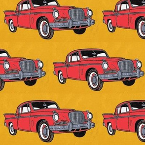 Big red finned 1957 Studebaker Hawk on gold background