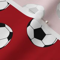 Two Inch Black and White Soccer Balls on Dark Red