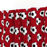 Two Inch Black and White Soccer Balls on Dark Red