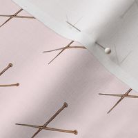 knitting needles on light pink background