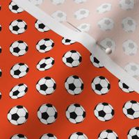 Half Inch Black and White Soccer Balls on Red-Orange