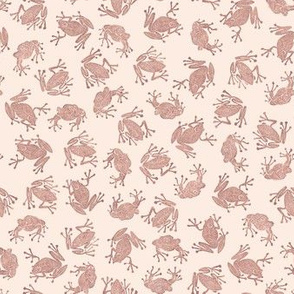 small terracotta frogs on pale pink