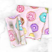 Scattered Rainbow Donuts on pale spotty pink - large scale