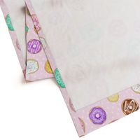 Scattered Rainbow Donuts on pale spotty pink - large scale